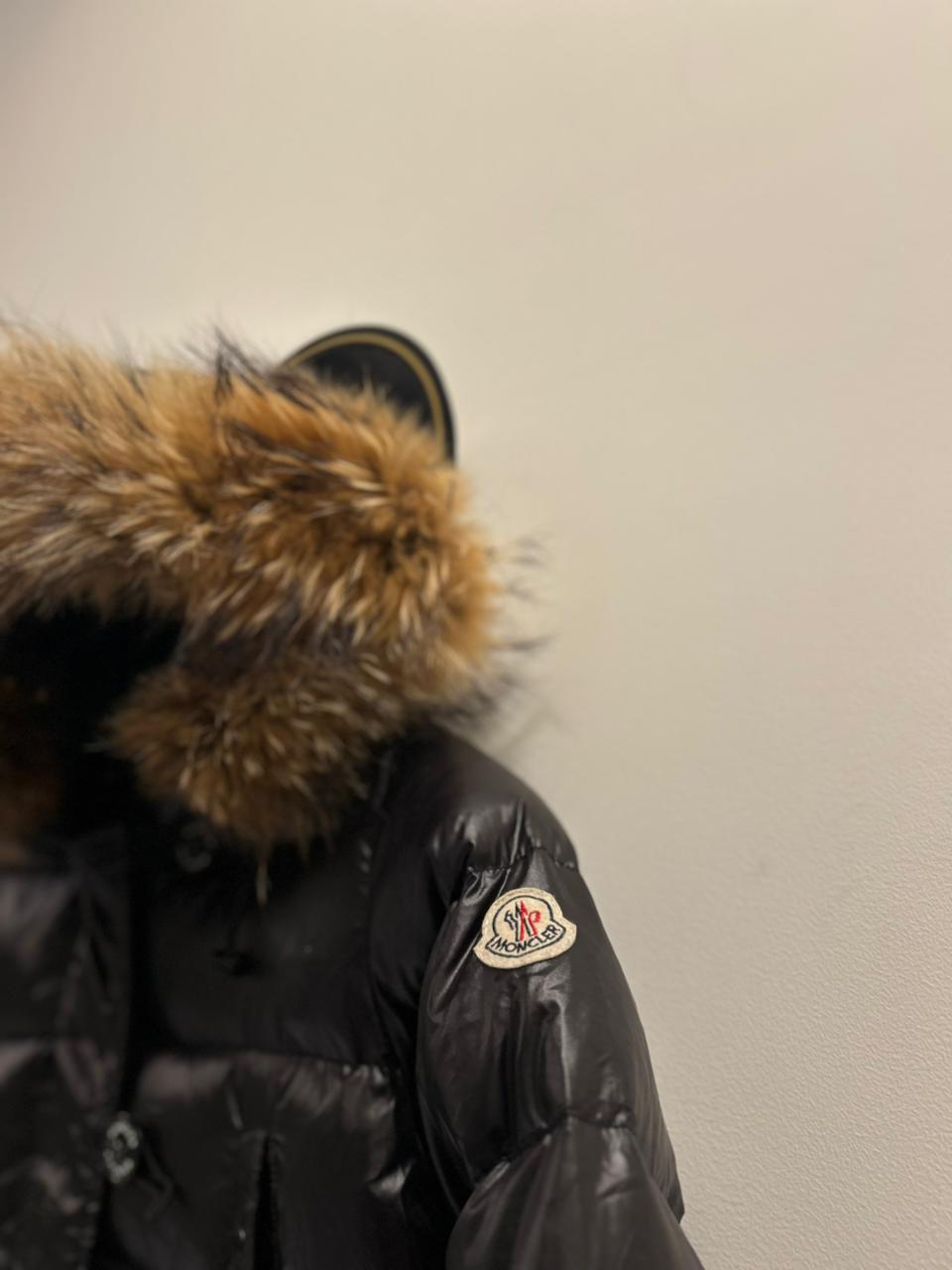 Moncler Women's down puffer jacket with a fur-trimmed hood.