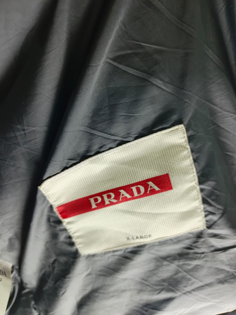 Prada-style black puffer jacket (triangle logo)